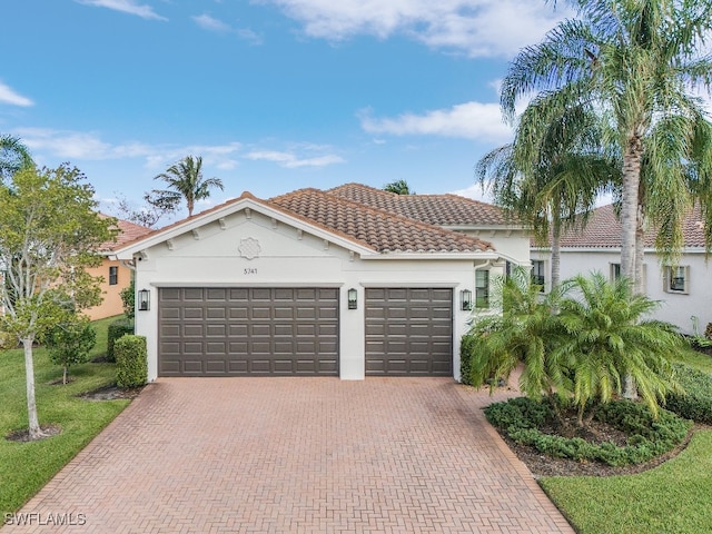 3741 Pleasant Springs Dr, Naples, FL 34119 - mediterranean / spanish home featuring a tiled roof, a garage, decorative driveway, and stucco siding