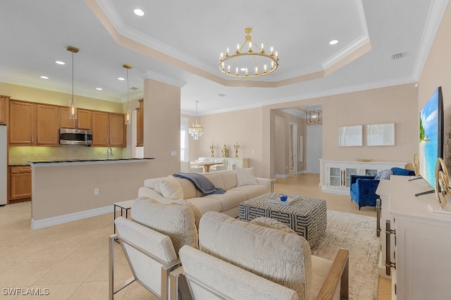 tiled living room featuring a raised ceiling, crown molding, sink, and a chandelier