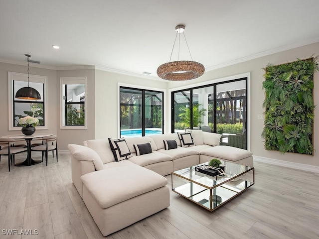 living room with light hardwood / wood-style flooring, a healthy amount of sunlight, and crown molding