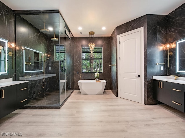 bathroom featuring wood-type flooring, vanity, tile walls, and independent shower and bath