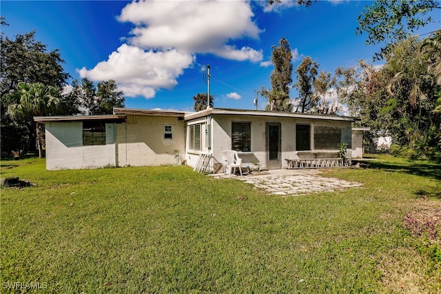 rear view of house with a yard and a patio area