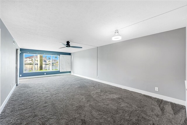 carpeted empty room with baseboards, a textured ceiling, and a ceiling fan