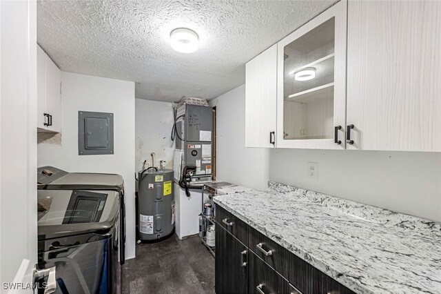 kitchen featuring glass insert cabinets, washer and clothes dryer, water heater, electric panel, and white cabinetry