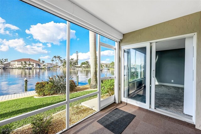 unfurnished sunroom featuring a water view