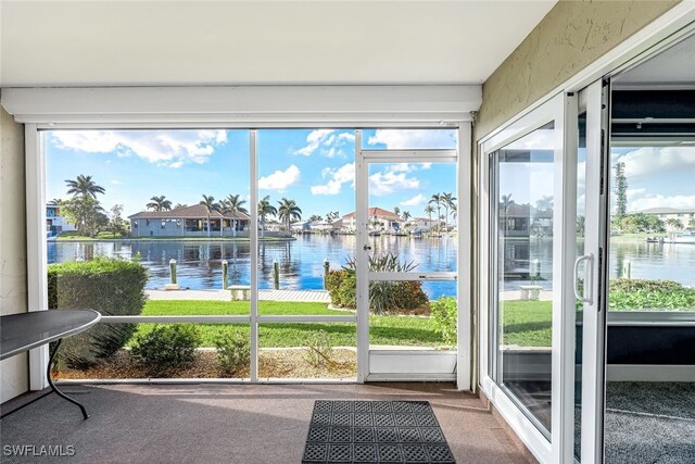 unfurnished sunroom featuring a water view and a wealth of natural light