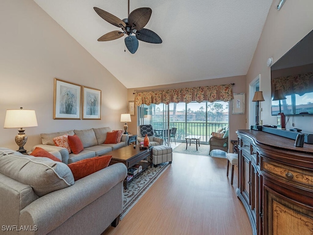 living room with light wood-type flooring, high vaulted ceiling, and ceiling fan