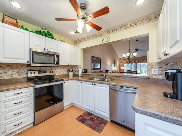 kitchen with sink, white cabinetry, stainless steel appliances, and light wood-type flooring