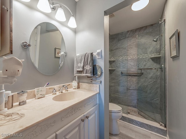 bathroom featuring vanity, toilet, a shower with shower door, and wood-type flooring