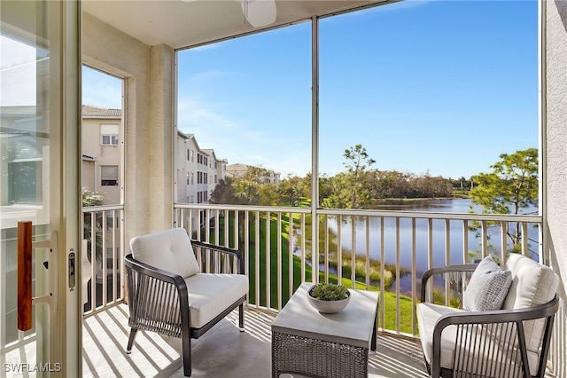 sunroom featuring a water view