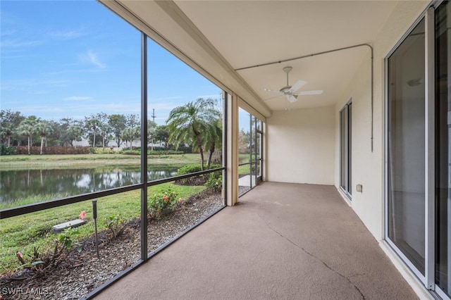 unfurnished sunroom with a water view and ceiling fan