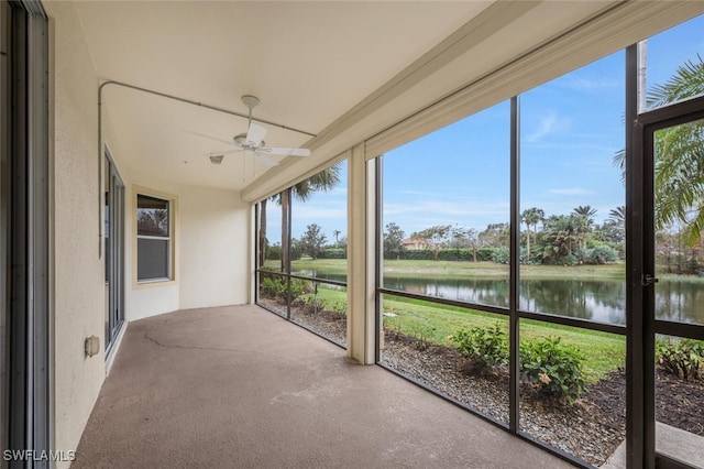 unfurnished sunroom with a water view, a healthy amount of sunlight, and ceiling fan