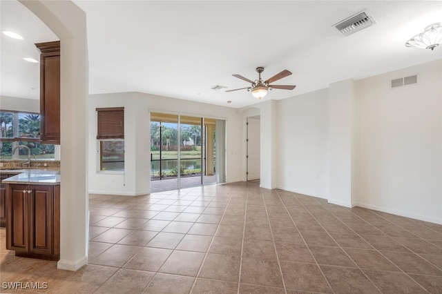 spare room featuring light tile patterned floors, sink, and ceiling fan