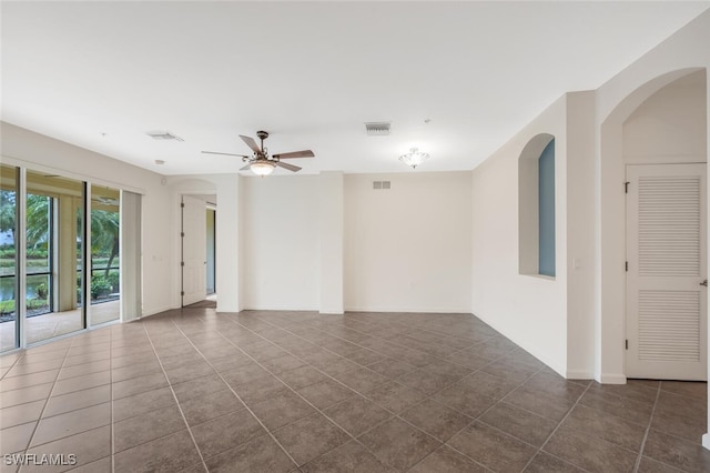 tiled spare room featuring ceiling fan