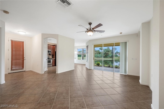 tiled empty room featuring ceiling fan