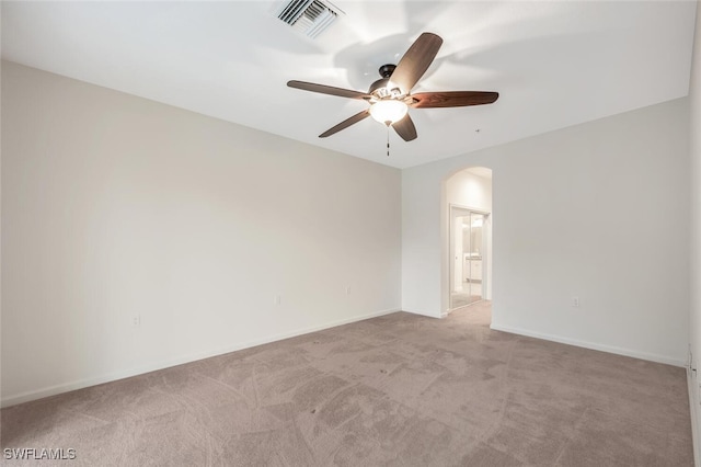 spare room featuring light colored carpet and ceiling fan