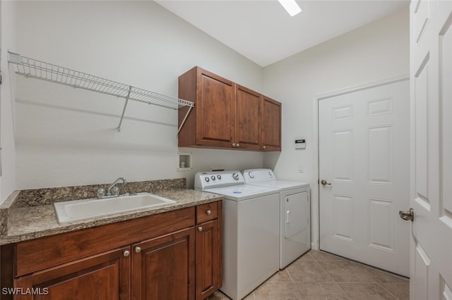 laundry area with cabinets, washing machine and dryer, sink, and light tile patterned flooring