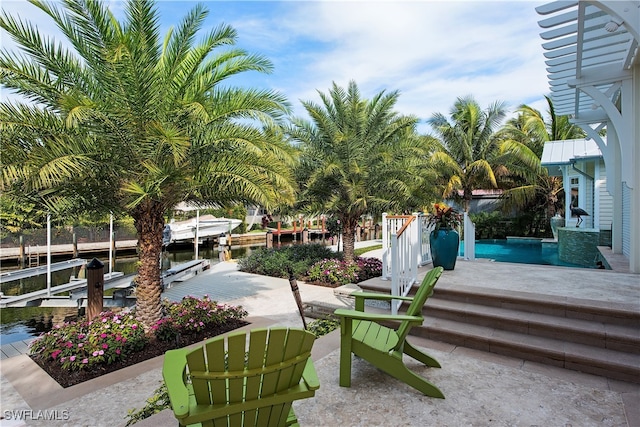 view of property's community featuring a water view, a patio area, and a dock