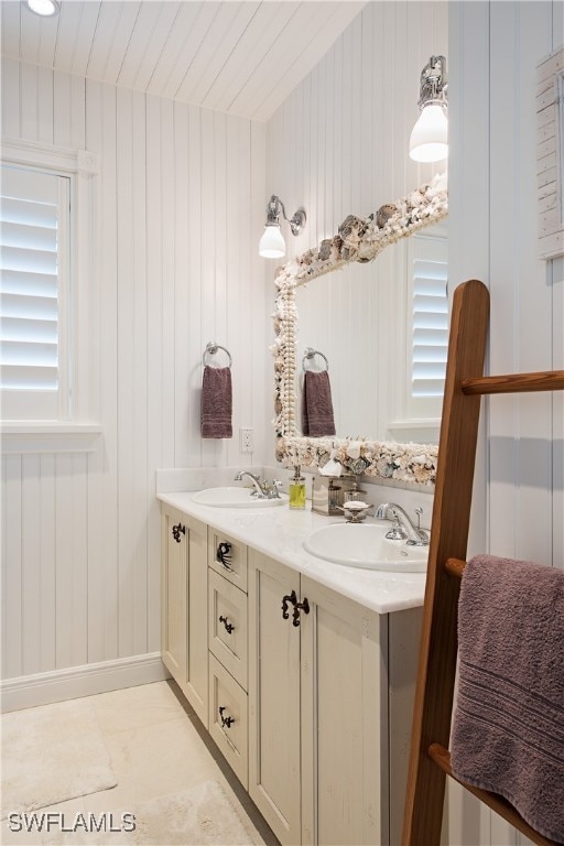 bathroom with tile patterned floors, vanity, and wood walls