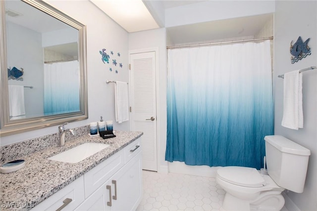 bathroom featuring toilet, tile patterned flooring, and vanity