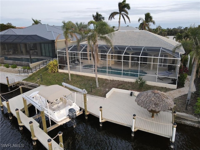 view of dock with a patio area, a lanai, and a water view