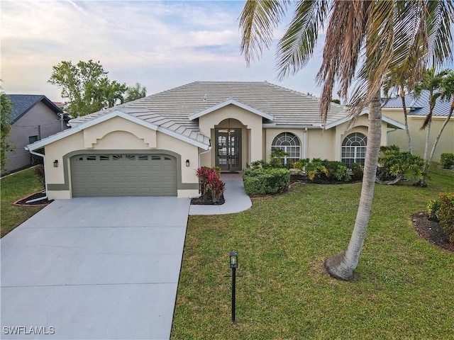 view of front of property with french doors, a garage, and a front yard