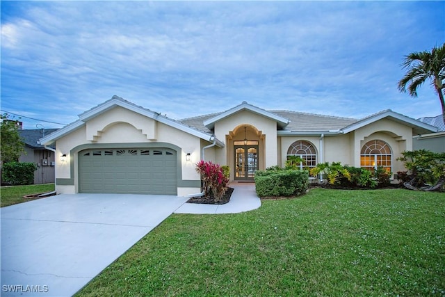 single story home with a garage, a front yard, and french doors