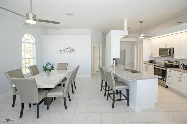 dining room featuring ceiling fan and sink