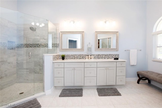 bathroom featuring backsplash, tile patterned floors, a shower with door, and vanity