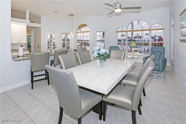 tiled dining space with ceiling fan