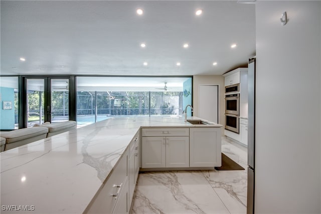 kitchen featuring white cabinets, plenty of natural light, and sink