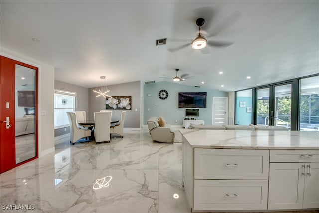 kitchen with french doors, ceiling fan with notable chandelier, light stone countertops, decorative light fixtures, and white cabinetry