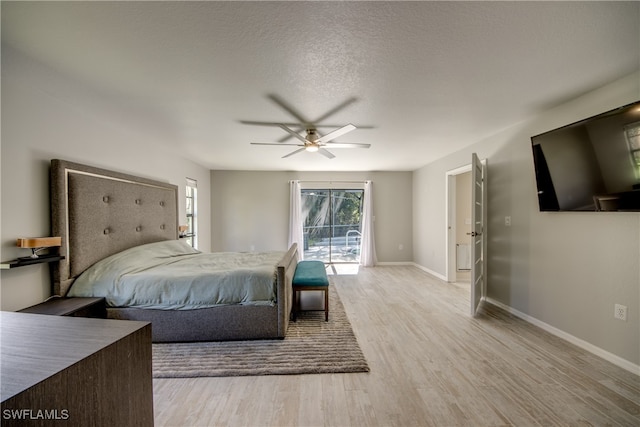 bedroom featuring ceiling fan, a textured ceiling, access to outside, and light hardwood / wood-style flooring