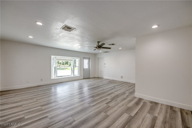 spare room with ceiling fan, a textured ceiling, and light hardwood / wood-style flooring