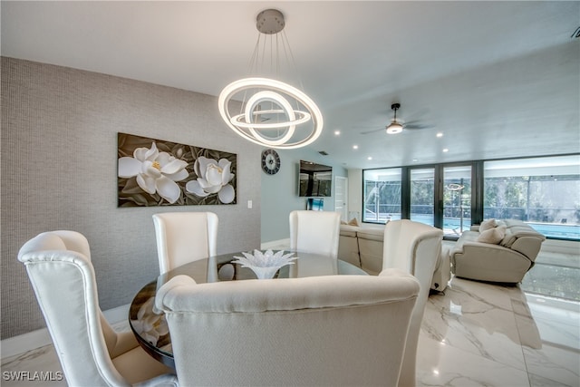 dining space featuring ceiling fan with notable chandelier