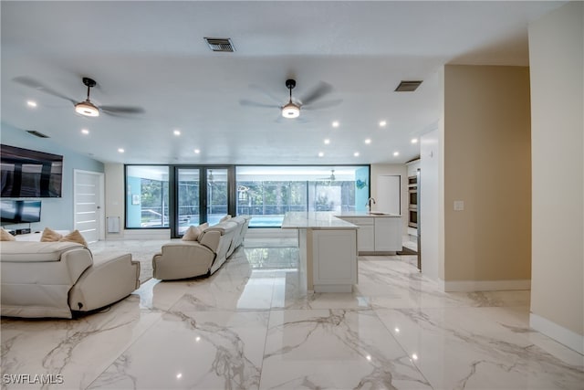 living room featuring ceiling fan and sink