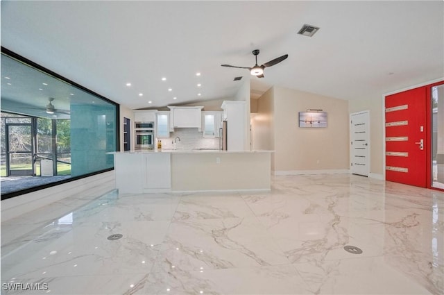 unfurnished living room featuring lofted ceiling, sink, and ceiling fan