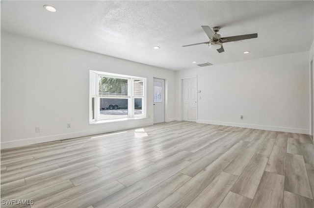 unfurnished room featuring ceiling fan, a textured ceiling, and light hardwood / wood-style flooring