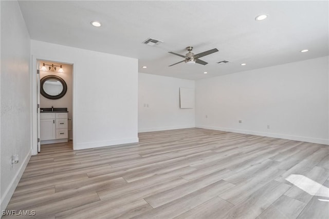 empty room with ceiling fan and light hardwood / wood-style flooring