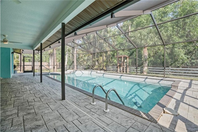 view of swimming pool with a playground, a patio, and glass enclosure