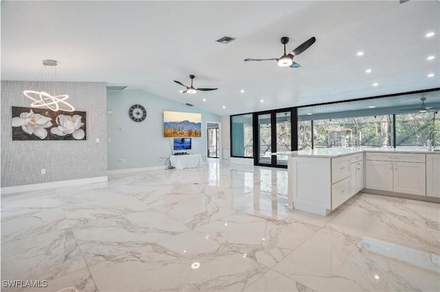 kitchen with white cabinetry, lofted ceiling, plenty of natural light, and hanging light fixtures