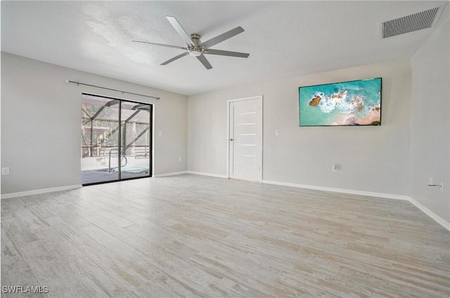 empty room featuring ceiling fan, a textured ceiling, and light wood-type flooring