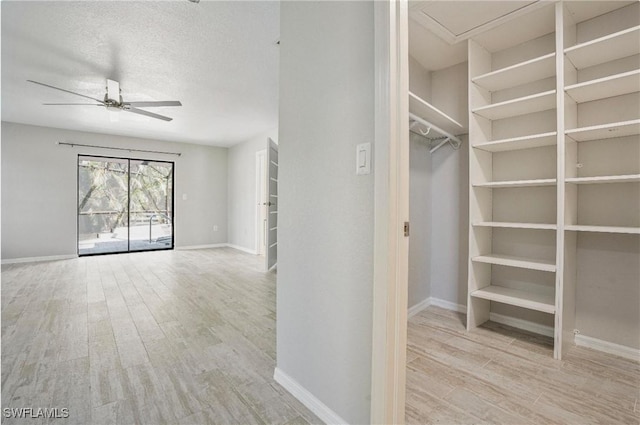 walk in closet featuring ceiling fan and light wood-type flooring