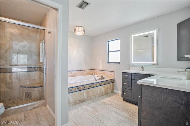 full bathroom featuring vanity, hardwood / wood-style floors, toilet, and separate shower and tub