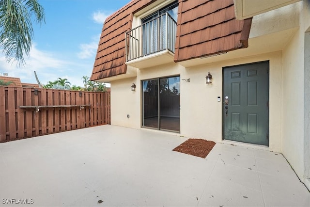 property entrance featuring a balcony and a patio