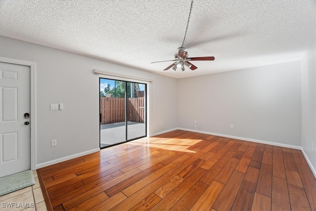 empty room featuring ceiling fan, light hardwood / wood-style floors, and a textured ceiling