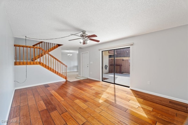 empty room with ceiling fan, light hardwood / wood-style floors, and a textured ceiling