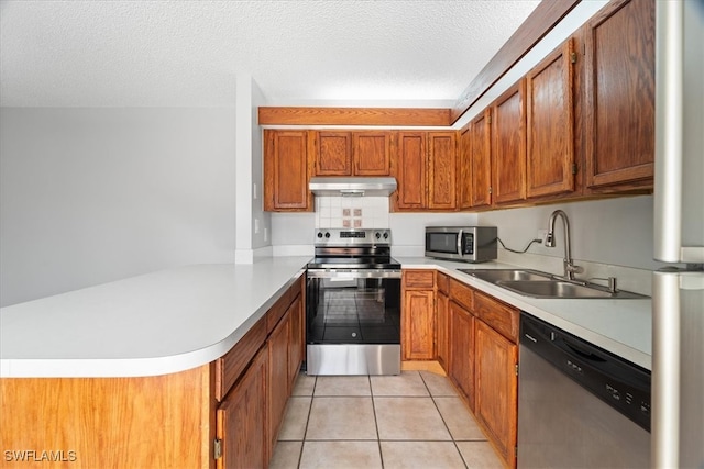 kitchen with kitchen peninsula, a textured ceiling, stainless steel appliances, sink, and light tile patterned floors