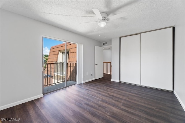 unfurnished bedroom with dark hardwood / wood-style floors, ceiling fan, access to exterior, a textured ceiling, and a closet