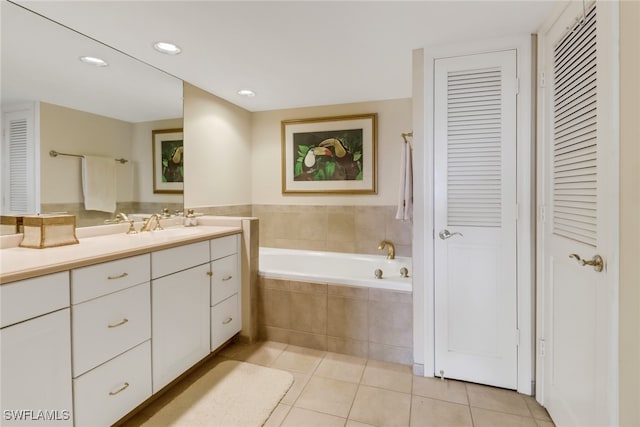 bathroom featuring tile patterned flooring, vanity, and a relaxing tiled tub