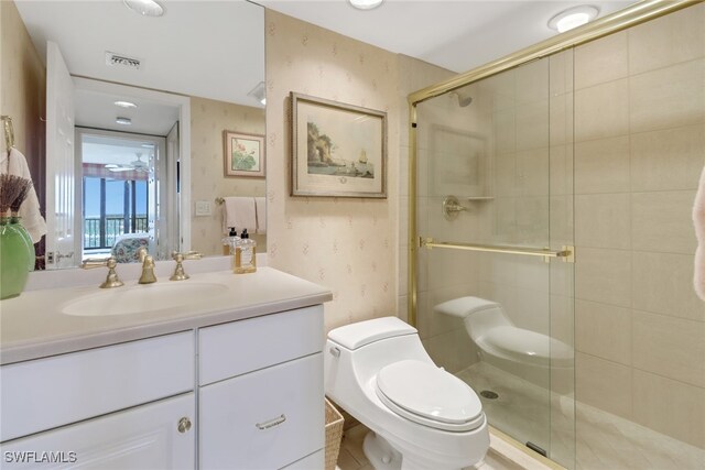 bathroom with tile patterned floors, vanity, toilet, and a shower with door